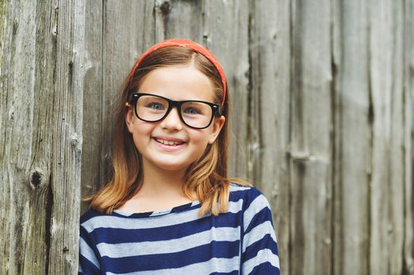 پرتره در فضای باز یک دختر بچه ناز 9 ساله زیبا که عینک دارد