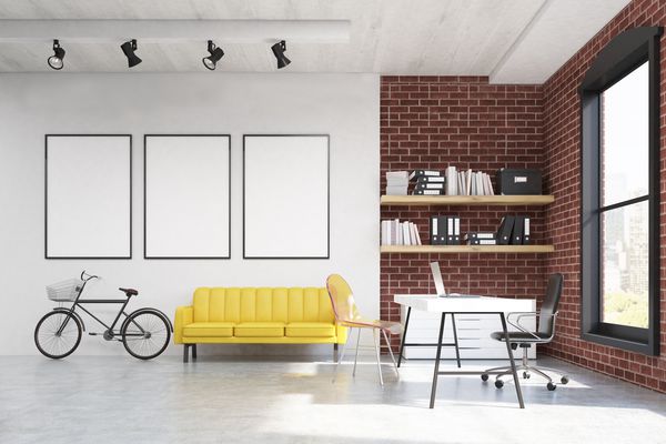 با یک میز سفید مبل زرد با سه پوستر قاب در بالای آن مطالعه کنید یک دوچرخه و یک قفسه کتاب در پس زمینه رندر سه بعدی مدل آزمایشگاهی ماکت