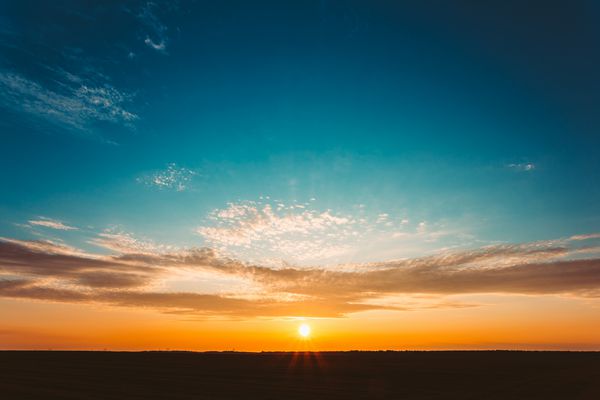 طلوع آفتاب طبیعی غروب بر روی مزرعه یا علفزار آسمان دراماتیک روشن و زمین تاریک منظره حومه شهر زیر منظره رنگارنگ منظره در غروب خورشید طلوع خورشید Sun Over Skyline افق رنگهای گرم