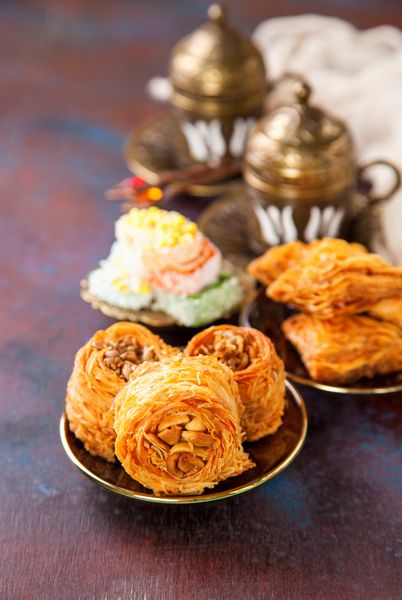 دسرهای سنتی عربی کونفا و باقلوا با عسل و آجیل تمرکز انتخابی فضا را کپی کنید