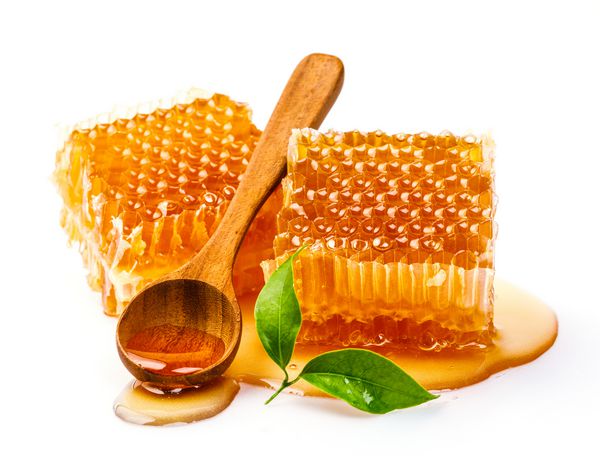 لانه زنبوری با قاشق و برگ عسل جدا شده در پس زمینه سفید محصولات سالم با استفاده از مواد طبیعی آلی