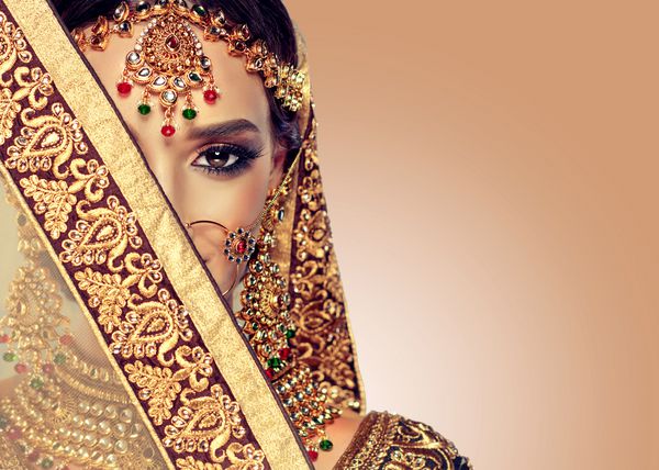 لبخند پرتره از دختر زیبا هندی مدل زن جوان هندی با ست جواهرات کولدان طلایی لباس سنتی هندی lehenga choli