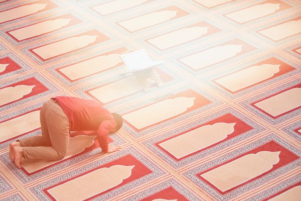 یک مرد مسلمان مذهبی که در داخل مسجد نماز می خواند
