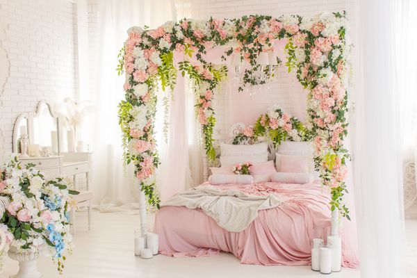 اتاق خواب صورتی با تختخواب با پرده گل و منسوجات صورتی روی تخت