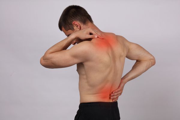 مرد عضلانی که از درد کمر و گردن رنج می برد تسکین درد مفهوم کایروپراکتیک ورزش آسیب دیدگی