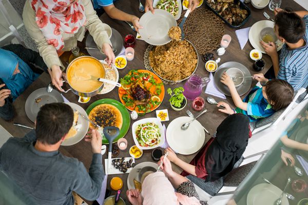 نمای برتر خانواده و دوستان که در جدول غذا می خورند