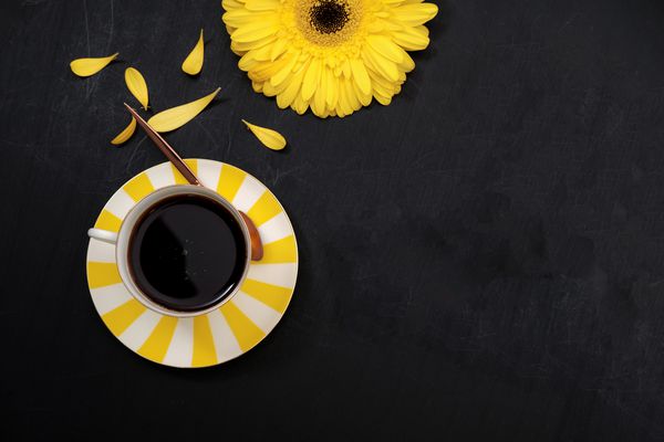 فنجان قهوه و گل زرد دراز کشیدن نمای بالا