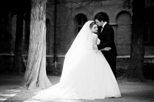 زن و شوهر عروسی فوق العاده که در روز عروسی خود در پارک راه می روند عکس سیاه و سفید