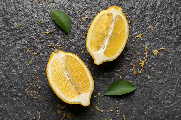 لیمو خرد شده خوشمزه را با پوست تیره در زمینه تیره رنگ کنید