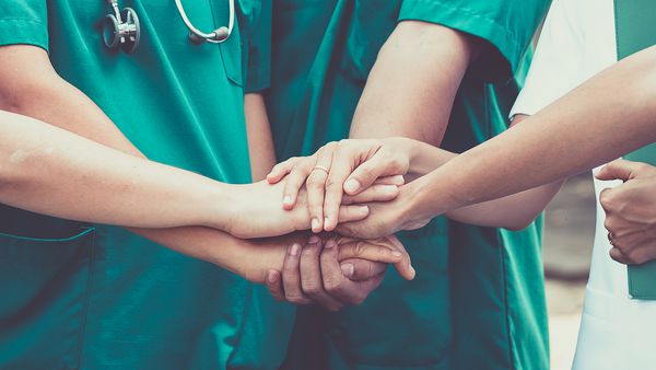 گروه پزشکان و پرستاران برای اعتماد به نفس دست هماهنگی می کنند مفهوم کار تیمی در بیمارستان