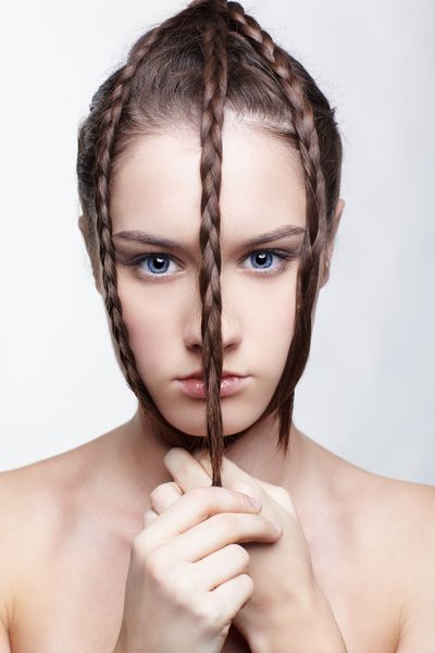 پرتره مدل موهای دختر زیبا با بندهای کشش موی خلاق بر روی صورت خود