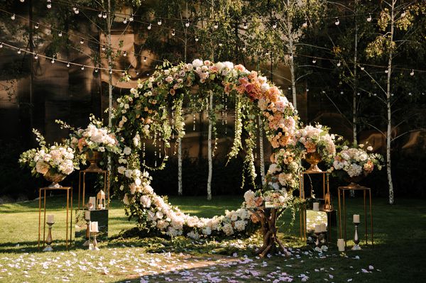 عروسی مراسم عروسی قوس طاق با گلهای صورتی و سفید که در جنگل ایستاده اند در منطقه مراسم عروسی تزئین شده است
