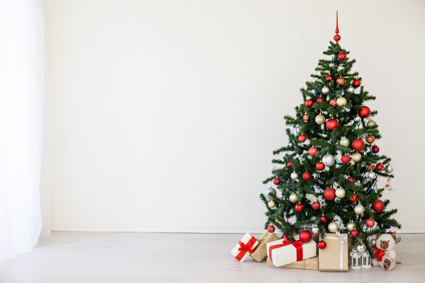 درخت کریسمس با هدایای قرمز در اتاق سفید کریسمس