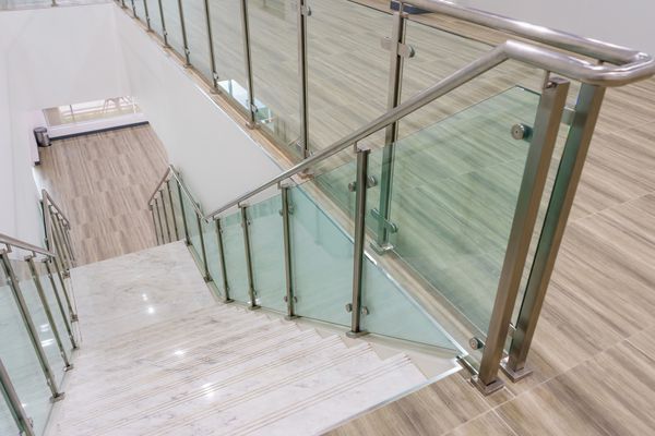 پله های مرمر سفید مدرن با نرده های استیل و شیشه ای در ساختمان جدید مدرن