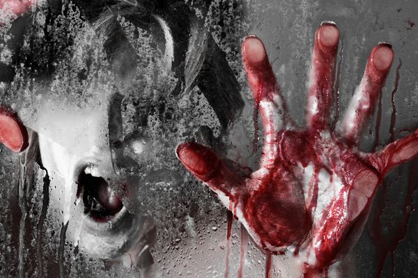 صحنه ترسناک زن با دست های خونین در برابر شیشه مرطوب
