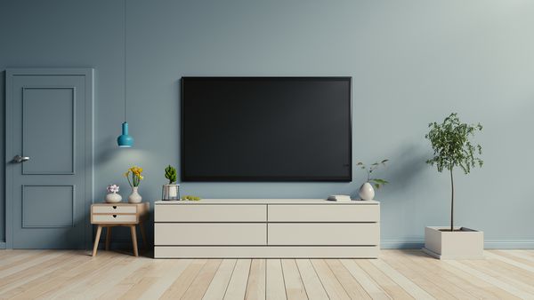 تلویزیون روی کابینت در اتاق نشیمن مدرن با پس زمینه دیوار آبی رندر سه بعدی