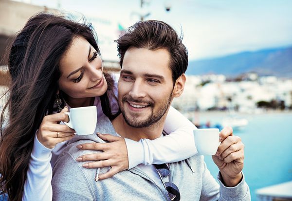 زن و شوهر جوان عاشق نوشیدن قهوه در یک رستوران در فضای باز