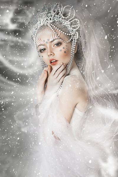 نزدیک عکس پرتره دختر زیبا آرایش سفید حرفه ای زمستانی مو در برف ملکه برفی با تاج زیبا قلعه برفی