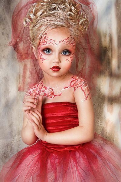 دختر زیبا و زیبا با لباس قرمز نزدیک عکس پرتره با هنر چهره گل قرمز