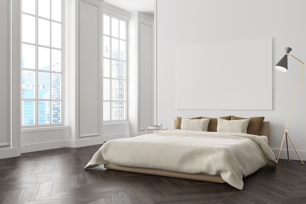 گوشه اتاق خواب سفید با کف چوبی تیره یک تخت خواب استاد با پوستر که در بالای آن آویزان است و پنجره های بزرگ رندر سه بعدی را مسخره کنید