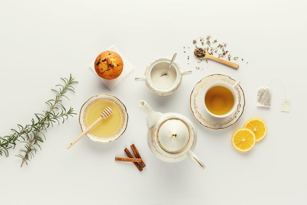 چای روشن زیبا تنظیم شده است گلدان های چای و سرامیک سفید و مواد چای بالای میز سفید