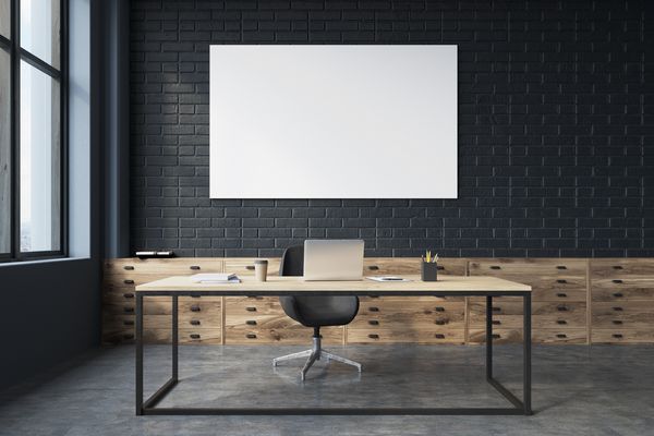 روتوش جانبی یک دفتر مدیرعامل آجر سیاه با یک کف بتونی یک میز بزرگ با یک کامپیوتر روی آن و یک پوستر نمای جلویی رندر سه بعدی را مسخره کنید