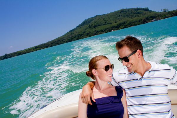 یک زن و شوهر جوان جذاب که با هم در یک قایق در فضای باز با هم استراحت می کنند