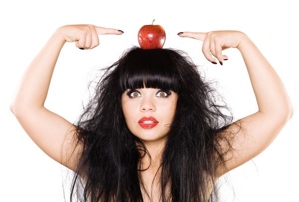 زن جوان زیبا با سیب قرمز روی سرش