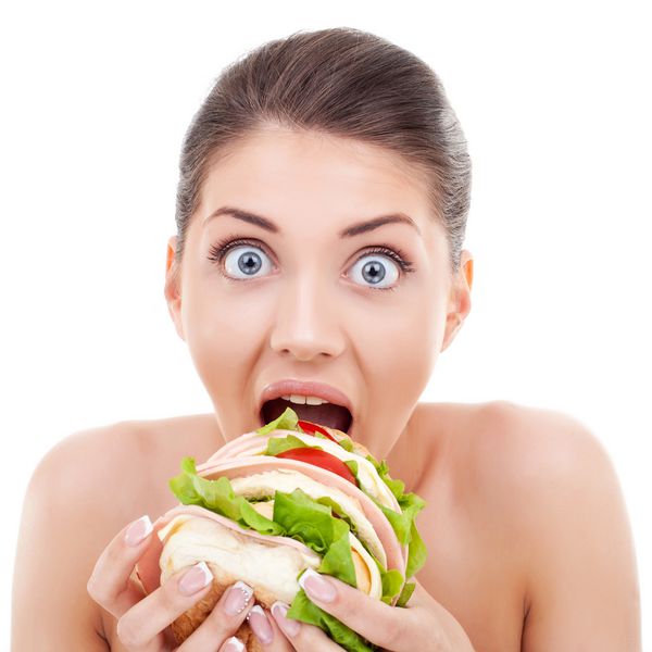 زنی با چشم های بزرگ گرد که یک ساندویچ جالب جالب دارد که می خورد