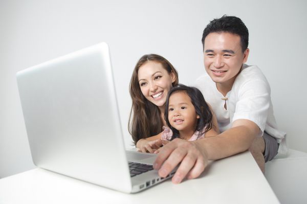 خانواده آسیایی با استفاده از لپ تاپ با دختر