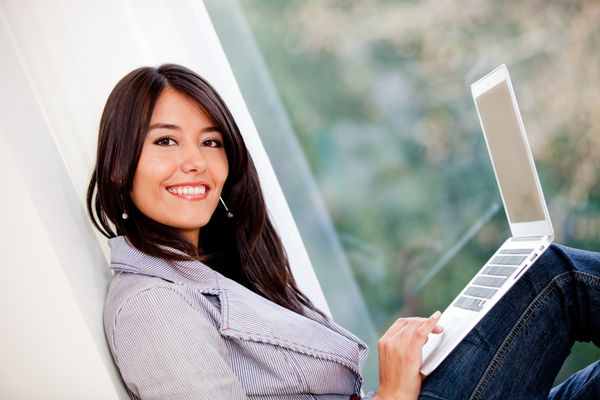 زن مدیریت تجارت آنلاین خود در خانه و لبخند زدن