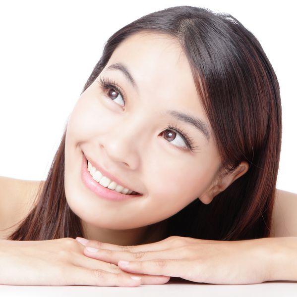 چهره زن زیبا آسیایی که لبخند بر روی زمینه سفید دارد جدا شده است