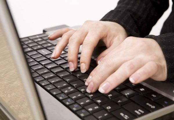 دستان زن روی صفحه کلید لپ تاپ