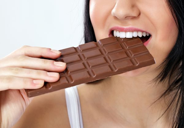 زن جذاب جوان شکلات می خورد نزدیک شوید