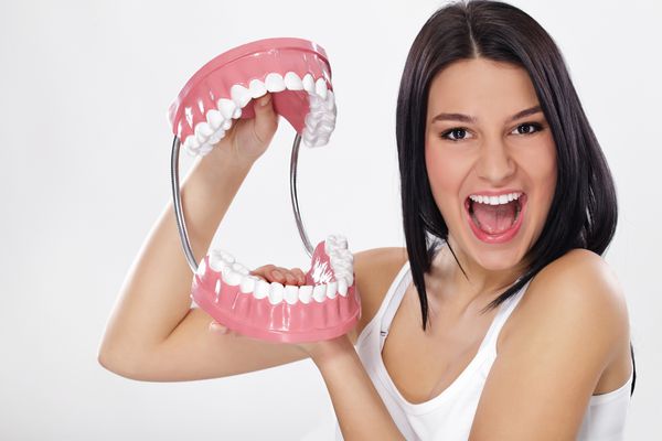 زن خنده دار که فک های باز را نشان می دهد دندان های سالم نشان می دهد