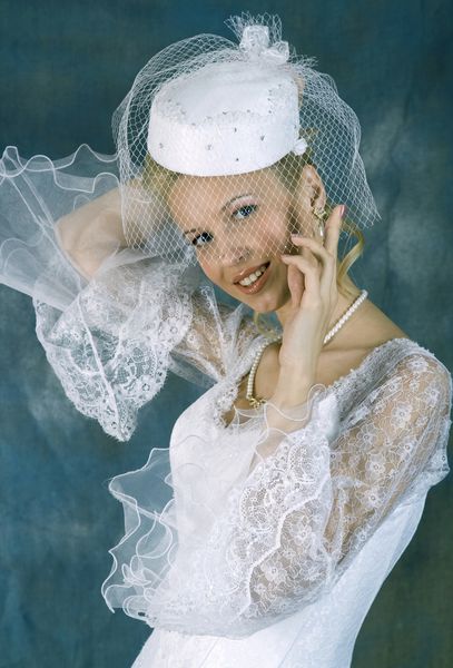 پرتره لبخند زدن به لباس سفید و کلاه با حجاب در زمینه روشن عکس استودیو