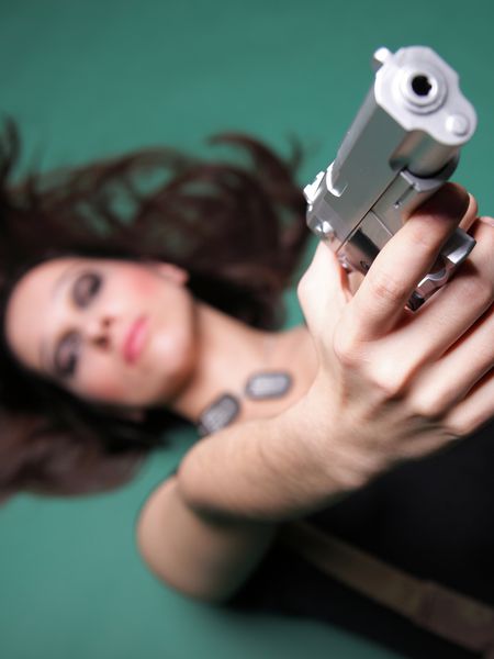 زن جوان با رنگ قرمز با اسلحه در زمینه سبز