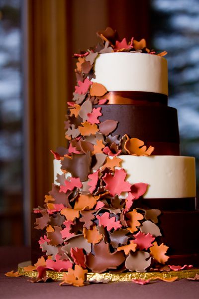 کیک عروسی فانتزی با مضمون پاییزی که برگهای شکر در کنار آن قرار دارد
