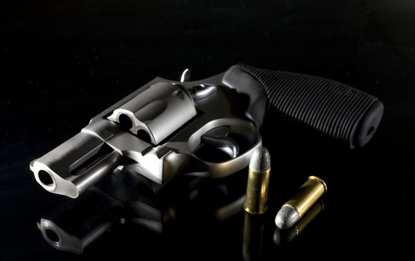 Revolver که روی یک پس زمینه سیاه و روشنایی جانبی قرار دارد