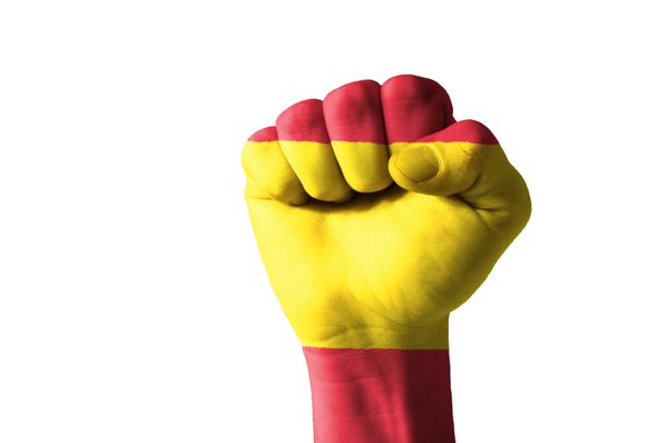 تصویر کم کلید از یک مشت که به رنگ پرچم اسپانیا رنگ شده است
