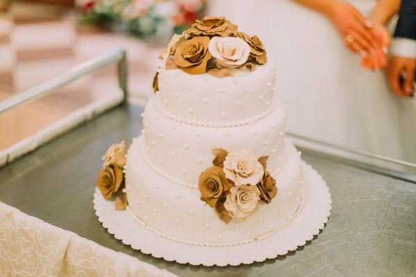 کیک عروسی زیبا که با گلهای بژ و هلو تزیین شده است