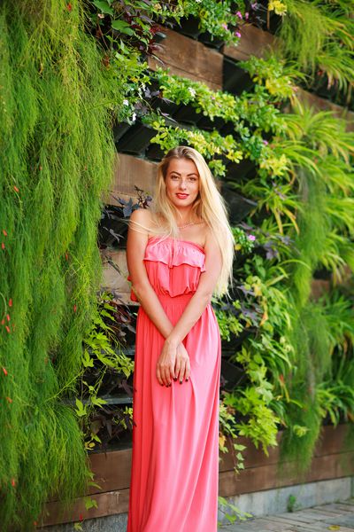 زن جوان زیبا در باغ شکوفه سبز تابستانی
