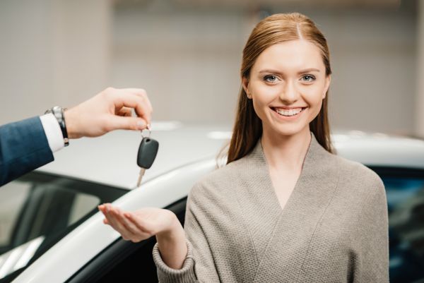 فروشنده دادن کلید ماشین به زن جوان زیبا صاحب جدید