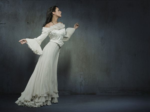 زن زیبا با پوشیدن لباس سفید بر روی دیوار دیوانه وار