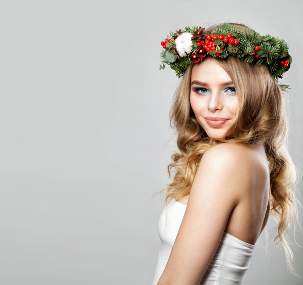 زن جوان و زیبا با موهای موج دار و کریسمس یا تاج های سال نو مفهوم زیبایی درمان صورت و زیبایی