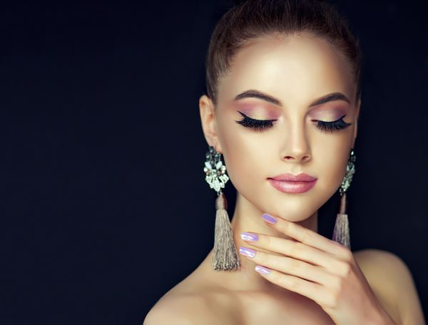 دختر مدل زیبا با مانیکور مروارید روی ناخن ها آرایش و لوازم آرایشی مد گوشواره های بزرگ طوسی جواهرات رنگ خاکستری را نشان می دهد