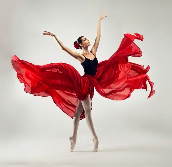 بالرینا باله زن برازنده جوان با لباس حرفه ای کفش و دامن بدون وزن قرمز نشان دهنده مهارت رقصیدن است زیبایی باله کلاسیک