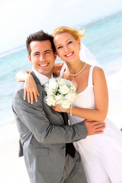 زن و شوهر شاد شاد که در ساحل ایستاده اند