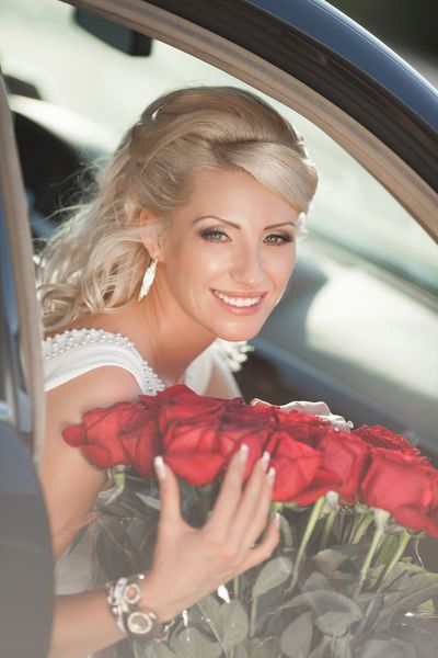 زن زیبا با گل و ماشین لوکس در فضای باز
