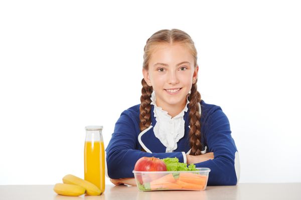 دختر مدرسه ای در هنگام ناهار خوردن غذای سالم